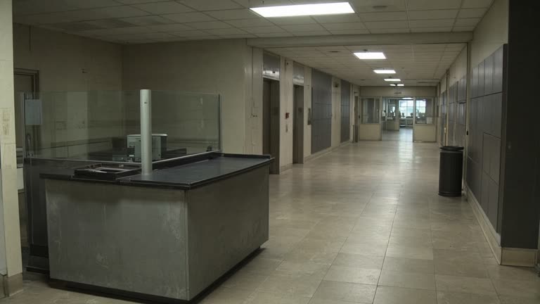 Federal office building lobby with security desk and muted fluorescent lighting, empty corridor, documentary wire photo, no logos or readable text