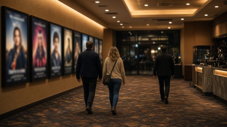 Movie theater lobby at night with blurred poster lightboxes, scattered ticket stubs on terrazzo flooring and empty velvet rope lines, no logos or readable text