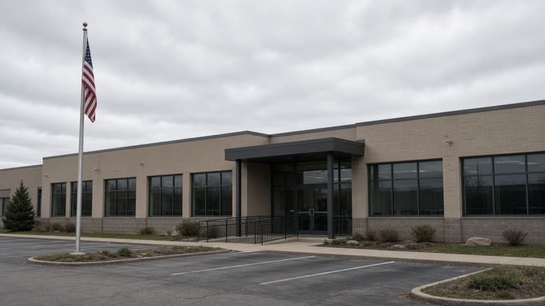 Credit union branch exterior with American flag pole and parking lot under overcast sky, documentary wire photo, no logos or readable text