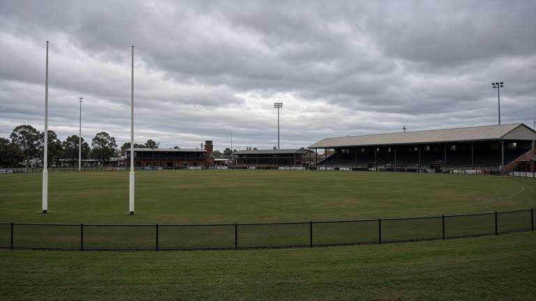 Empty Australian rules football oval at Kardinia Park with goal posts and low grandstand, overcast afternoon, no logos or readable text